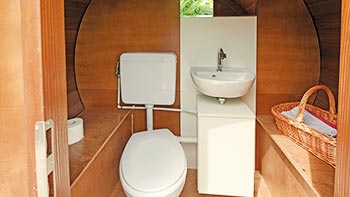 Sanitäreinrichtung mit Toilette und Waschbecken im Wohnfass
